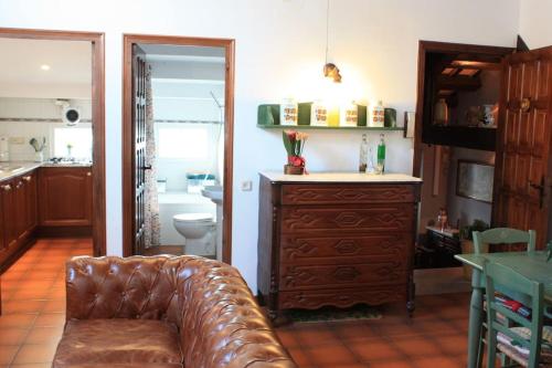 a living room with a leather couch and a bathroom at Cal Negre 2 in Vilassar de Mar