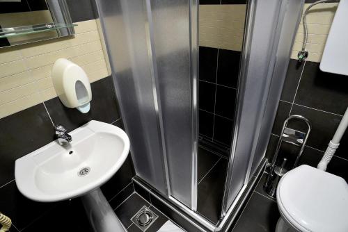 een kleine badkamer met een wastafel en een douche bij Hotel Golf in Kruševac