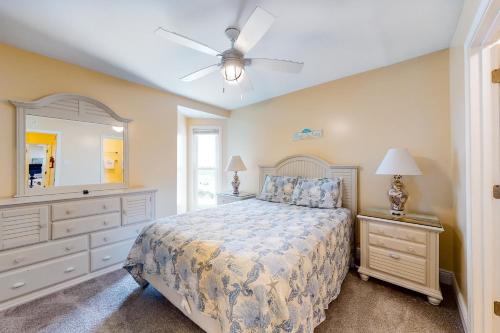 ガルフ・ショアーズにあるGulfside Townhomes #40のベッドとドレッサーと鏡のある寝室