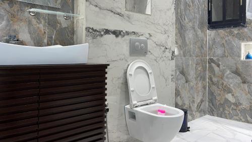 a bathroom with a toilet and a sink at Suna' a Home Bonapriso in Douala