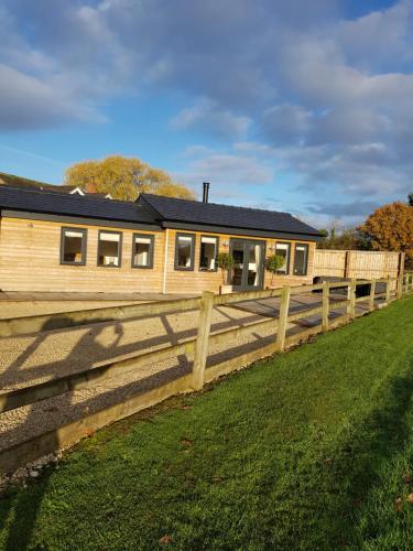 a wooden fence in front of a house at The Lodge in High Legh