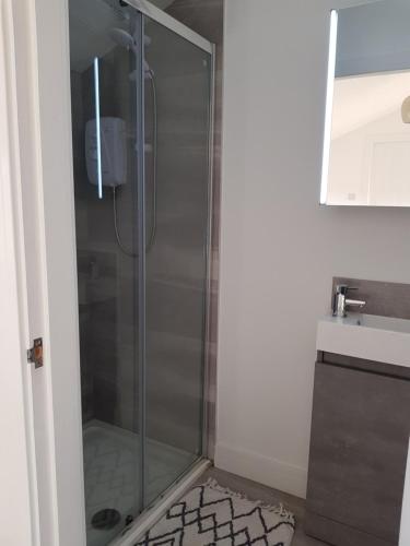 a shower with a glass door in a bathroom at The Lodge in High Legh
