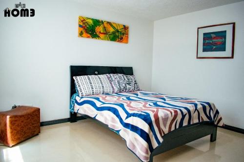 a bedroom with a bed with a colorful comforter at Lilas Home in Pasto