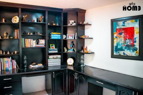 a black desk in a room with bookshelves at Lilas Home in Pasto