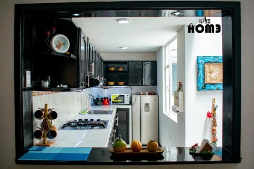 uma cozinha com armários pretos e um frigorífico branco em Lilas Home em Pasto