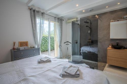 1 dormitorio con 1 cama con 2 toallas en Villa Catalpa, en Le Muy