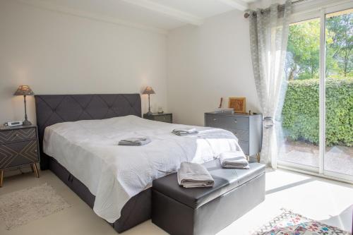 Un dormitorio con una cama grande y una ventana en Villa Catalpa, en Le Muy