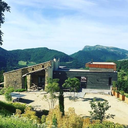 un grand bâtiment avec des montagnes en arrière-plan dans l'établissement Vues et nature exceptionnelles au coeur de 200 ha pour 16 pers, à Teyssières
