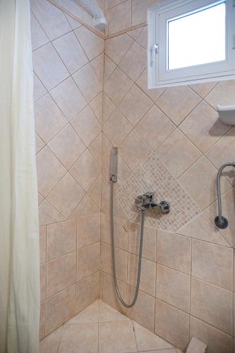 a bathroom with a shower with a shower curtain at Hotel Pithari in Agia Triada