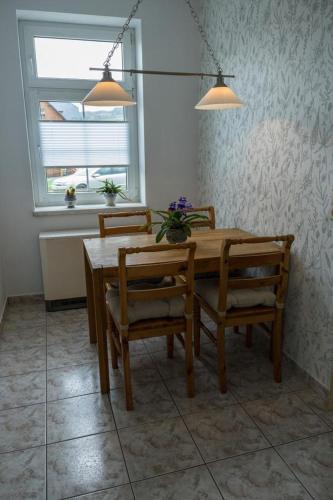 a dining room table with two chairs and a window at Ferienwohnung Otto in Klingenthal