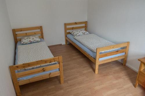 Habitación con 2 camas individuales y suelo de madera. en Ferienwohnung Otto en Klingenthal