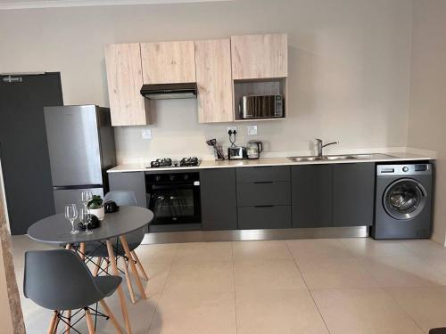 a kitchen with a sink and a table with chairs at 93 on new unique and classy in Midrand
