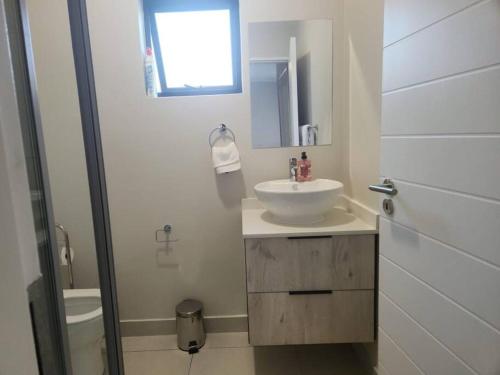 a white bathroom with a sink and a toilet at 93 on new unique and classy in Midrand