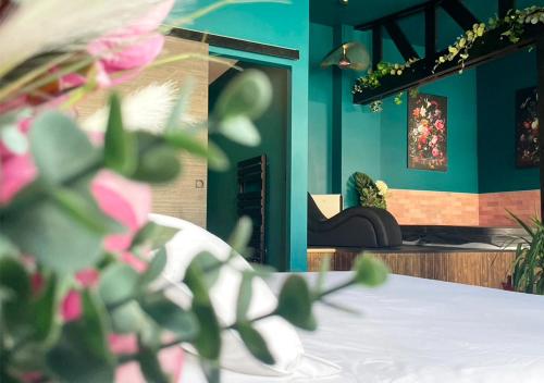 a room with blue walls and a table with pink flowers at NUITS D'EXIL in Gérardmer