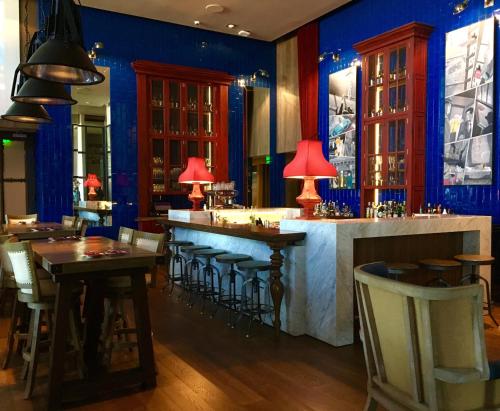 a bar in a restaurant with blue walls and tables at Hyatt Centric Montevideo in Montevideo