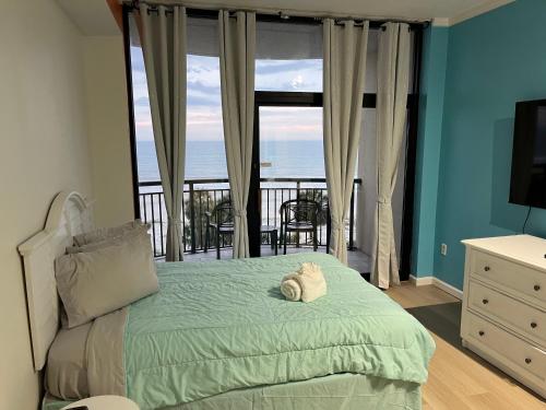 a bedroom with a bed with a view of the ocean at Breakers Resort in Myrtle Beach