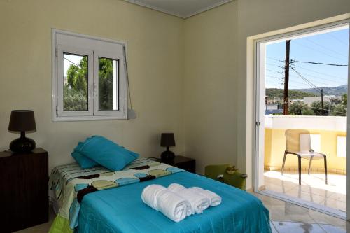 a bedroom with a bed with towels on it at LIVAS Almyri seafront flat in Káto Almirí