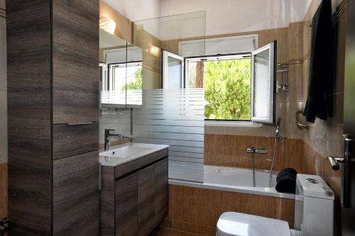 a bathroom with a sink and a tub and a toilet at Almyri seafront flat in Kato Almiri