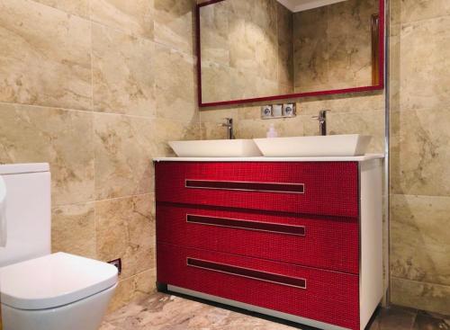a bathroom with a red cabinet with a sink at Villa turística Camina y Rioja in Cenicero