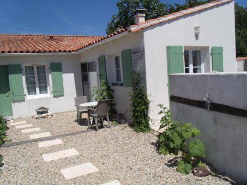 une maison avec une table et des chaises devant dans l'établissement Les Bois Flottés en Ré, à Sainte-Marie de Ré