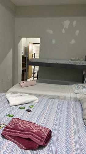 een slaapkamer met 2 bedden en handdoeken bij Pousada Corumba Center in Corumbá