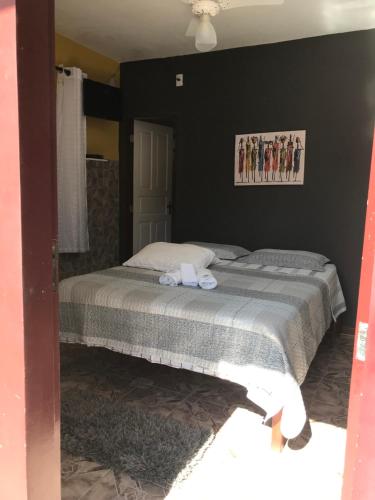 a bedroom with a bed and a black wall at Pousada Ciclo do Ouro in Paraty