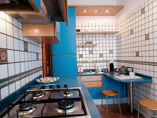 una cucina con piano cottura e parete blu di Appartamento luminoso Villa Pamphili a Roma