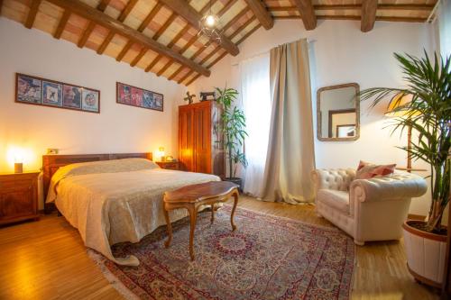 1 dormitorio con 1 cama, 1 silla y 1 sofá en Casale Vincenzo Country House, en Collecorvino