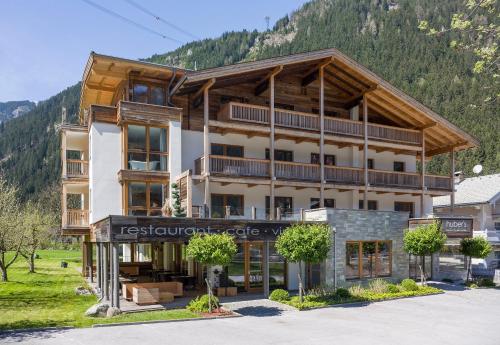 a large building with a mountain in the background at Huber's Boutique Hotel in Mayrhofen