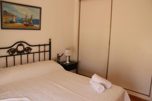 a bedroom with a bed with two towels on it at CABO DE PALOS ATICO LA GALERA parking in Cabo de Palos