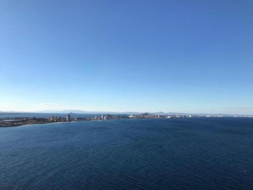 a large body of water with a city in the background at CABO DE PALOS ATICO LA GALERA parking in Cabo de Palos