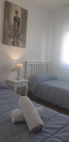 a bedroom with two beds and a picture of a man at CABO DE PALOS ATICO LA GALERA parking in Cabo de Palos