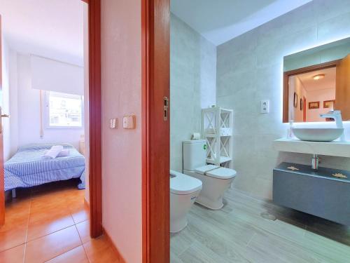 a bathroom with a toilet and a sink and a mirror at CABO DE PALOS ATICO LA GALERA parking in Cabo de Palos