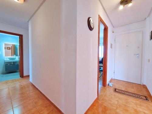 an empty hallway with a clock on a wall at CABO DE PALOS ATICO LA GALERA parking in Cabo de Palos