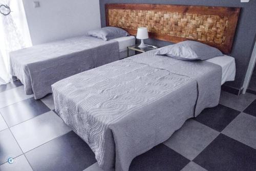 two beds in a bedroom with a checkered floor at Kolina D´Sol in Ponta do Sol