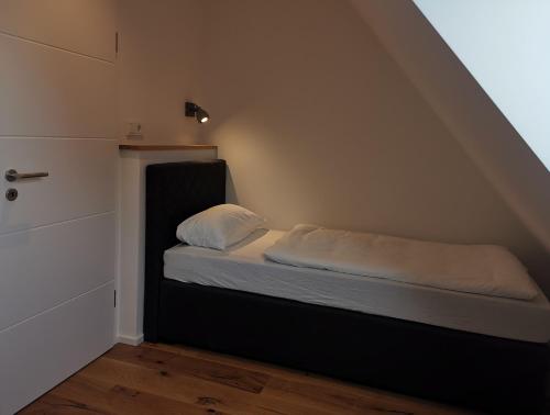 a small bedroom with a bed in the attic at Filder-Appartements in Filderstadt