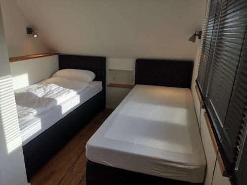a small bedroom with two beds and a window at Filder-Appartements in Filderstadt