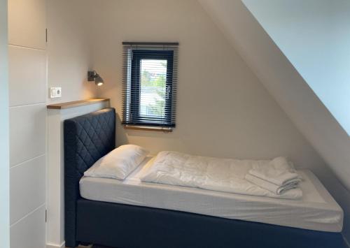 a bed sitting in a room with a window at Filder-Appartements in Filderstadt