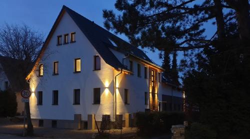 a large white house with lights on it at night at Filder-Appartements in Filderstadt