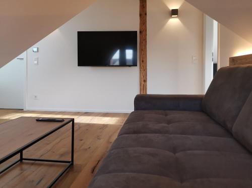 a living room with a couch and a tv at Filder-Appartements in Filderstadt