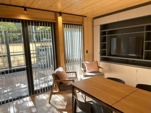 sala de estar con TV, mesa y sillas en Hermoso departamento de 3 ambientes con amplio jardin. 1V5 en San Martín de los Andes