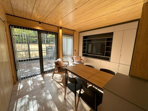 sala de estar con mesa, sillas y TV en Hermoso departamento de 3 ambientes con amplio jardin. 1V5 en San Martín de los Andes