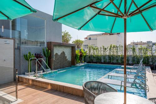 a swimming pool with a table and an umbrella at Royal Regency Palace Hotel in Rio de Janeiro