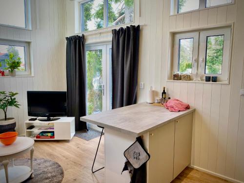 a kitchen with a island in a room with windows at Orres Guesthouse Stenhamra, Ekerö in Stenhamra