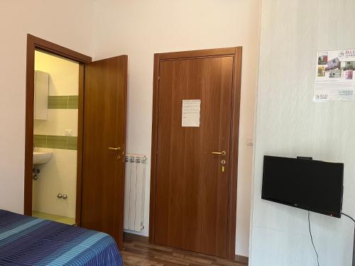 Schlafzimmer mit einem Bett, einem TV und einer Tür in der Unterkunft B&B D'Amare in San Salvo