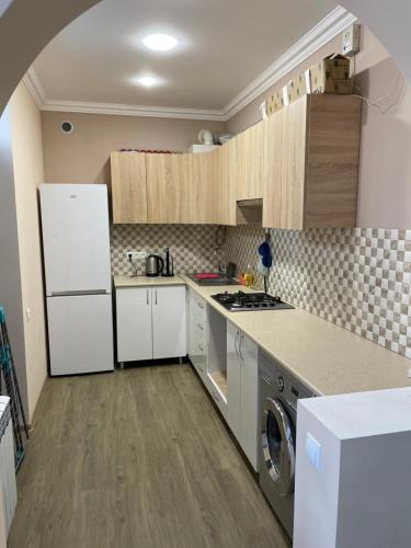 a kitchen with white cabinets and a washer at The Nest JERMUK in Jermuk