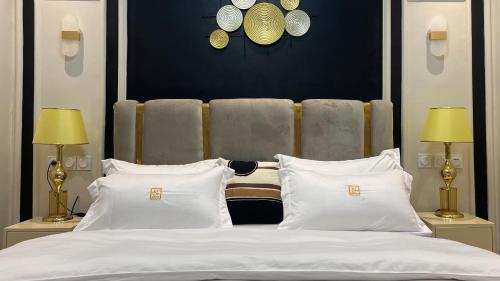 a bedroom with a large bed with white pillows at Suna' a Home Bonapriso in Douala