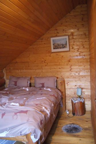 sypialnia z łóżkiem w drewnianym domku w obiekcie Musketeers Cabin w mieście Porumbacu de Sus