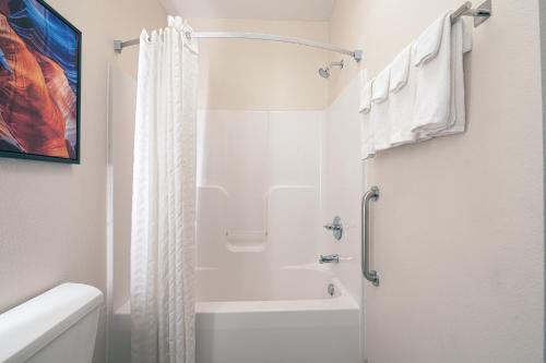 Candlewood Suites Merrillville, an IHG Hotel في ميريلفيل: حمام أبيض مع دش ومرحاض