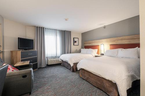 a hotel room with two beds and a flat screen tv at Candlewood Suites Merrillville, an IHG Hotel in Merrillville